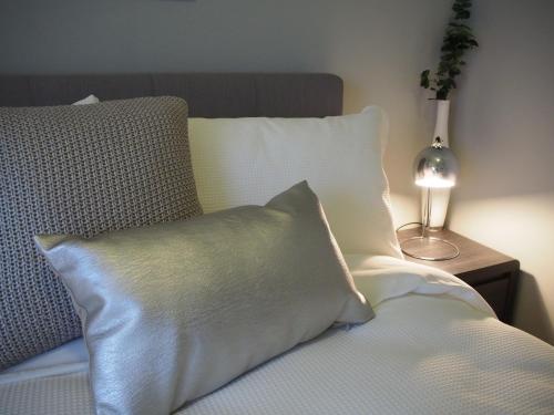 a bed with a pillow and a lamp on a table at City Quarters on Brewer in Perth