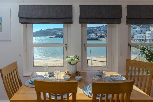 a dining room with a table with a view of the ocean at Harts Loft - On Beach - Panoramic Sea Views - By Harbour in St Ives