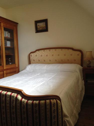 une chambre avec un grand lit avec une tête de lit en bois dans l'établissement villa manhé, à La Teste-de-Buch