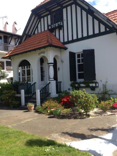 une maison noire et blanche avec des fleurs devant elle dans l'établissement villa manhé, à La Teste-de-Buch