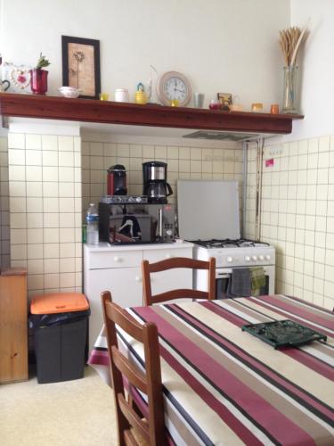 une cuisine avec une cuisinière et une table avec des chaises dans l'établissement villa manhé, à La Teste-de-Buch