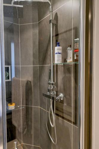d'une douche avec une porte en verre et un pommeau de douche. dans l'établissement Bel appartement pour 2 personnes by Weekome, à Paris