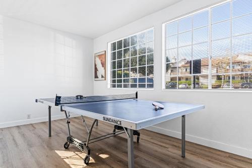 a ping pong table in a room with windows at Walk to Beach Pool Hot Tub Private Patio Parking Seabreeze Retreat in Dana Point