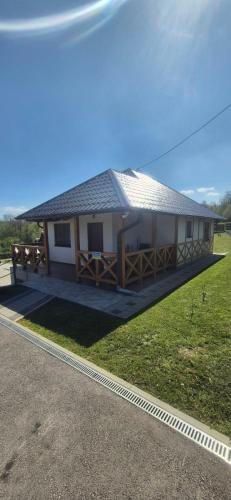 a house with a gambrel roof on the side of the road at Suncev Brijeg in Banja Luka