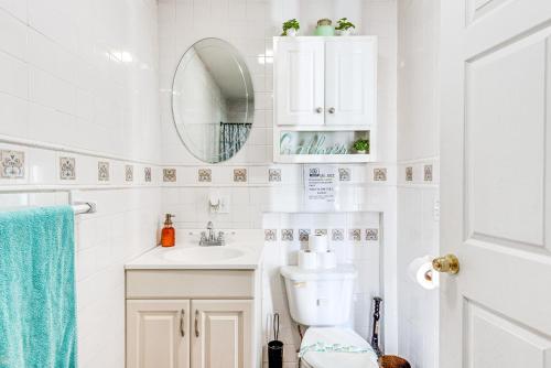 Un baño con inodoro, lavabo y espejo. en Game Room, Deck and Fire Pit Covington Township Gem, en Daleville