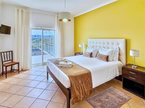 Un dormitorio con una cama grande y un balcón. en Villa Belchior, en Faro