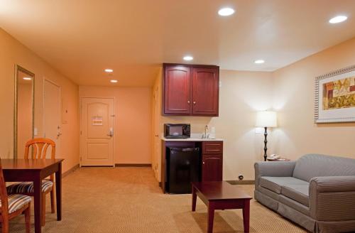 a living room with a couch and a kitchen at Holiday Inn Express Hotel & Suites Los Angeles Airport Hawthorne by IHG in Hawthorne