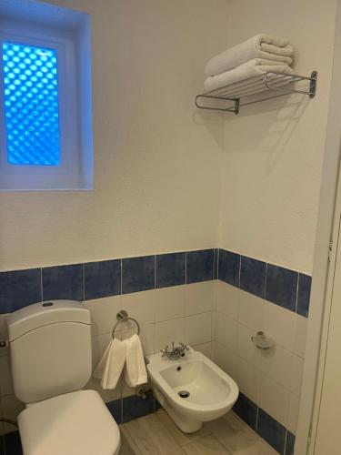a bathroom with a toilet and a sink and a window at Domina Coral Bay Aquamarine in Sharm El Sheikh