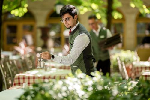 a man in a suit standing at a table at Hotel IMLAUER & Bräu in Salzburg
