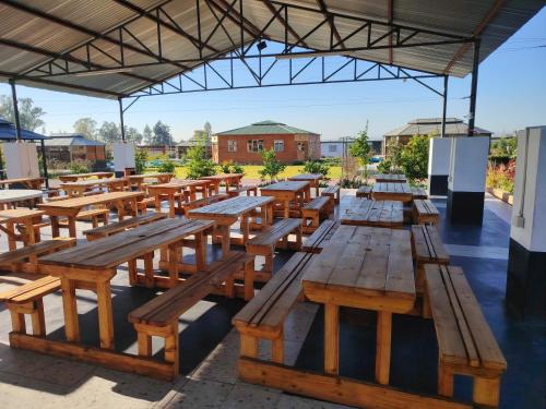 a group of wooden benches sitting under a building at 4th Avenue Themepark & Lodge in Rustenburg