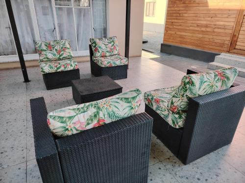 four wicker chairs withupholstery sitting in a building at 4th Avenue Themepark & Lodge in Rustenburg