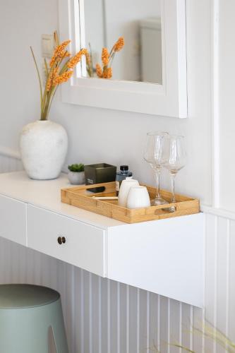 a shelf with wine glasses and a mirror at Neachora Beachfront Suites in Chania