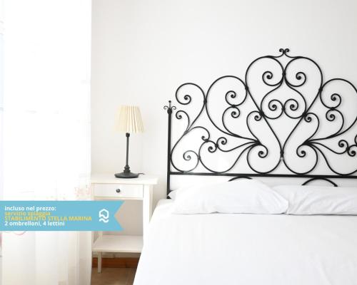 a bedroom with a white bed with a metal headboard at VIVA2 - Numana, quadrilocale in villa con piscina in Numana