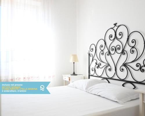 a white bed with a metal headboard in a bedroom at VIVA2 - Numana, quadrilocale in villa con piscina in Numana