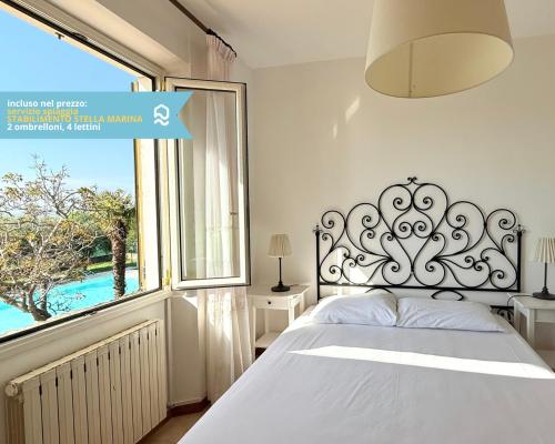 a bedroom with a bed and a large window at VIVA2 - Numana, quadrilocale in villa con piscina in Numana