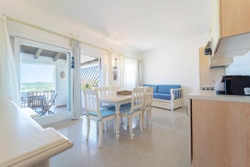 una cucina e una sala da pranzo con tavolo e sedie di -Vista Mare e Piscina- Dimora di alta classe per 6 a Liscia di Vacca
