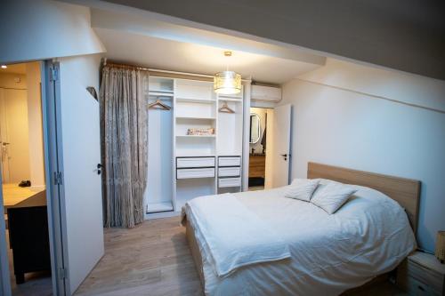 une chambre avec un lit blanc et une salle de bain dans l'établissement Beautiful apartment in the center of Cannes, à Cannes