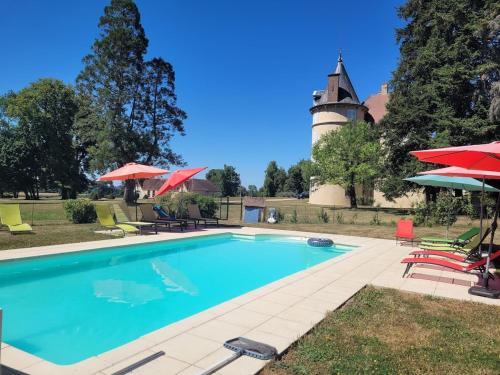 a swimming pool in front of a building with a lighthouse at Les Lavandins Château de Musigny in Musigny