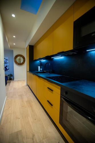 - une cuisine avec des armoires jaunes et un four avec plaques de cuisson dans l'établissement Beautiful apartment in the center of Cannes, à Cannes