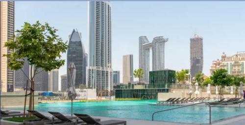 a large swimming pool in a city with buildings at Bellavista Apartments Holiday Homes LLC - Downtown Views II T1 - 2 Bedroom Apartment with Burj Khalifa View in Dubai