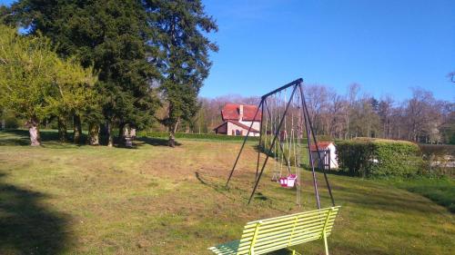 a swing in a field with a house in the background at Les Lavandins Château de Musigny in Musigny