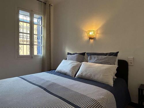 une chambre avec un lit avec une lumière sur le mur dans l'établissement Appart 2 pièces 2 couchages BANYULS SUR MER BN000-18A, à Banyuls-sur-Mer