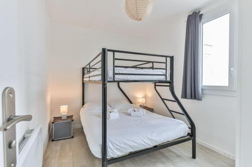 une chambre avec deux lits superposés et une fenêtre dans l'établissement Les Mouettes - Appartement bord de mer, à La Parée Preneau
