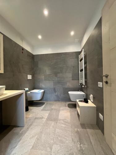 a bathroom with two sinks and two toilets in it at Casa Vacanze Ranuncolo 2 in Sùtrio