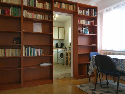 une pièce avec des étagères en bois avec une table et une cuisine dans l'établissement Le Verlaine, à Annecy