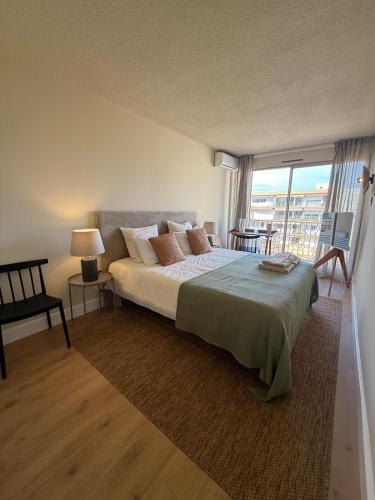 une chambre avec un grand lit et une grande fenêtre dans l'établissement Appartement Elégant 3 chambres Saint-Tropez, à Saint-Tropez