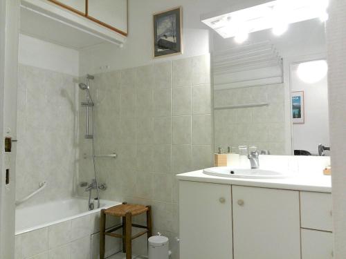 une salle de bain avec un lavabo, une baignoire et un miroir dans l'établissement Le Verlaine, à Annecy