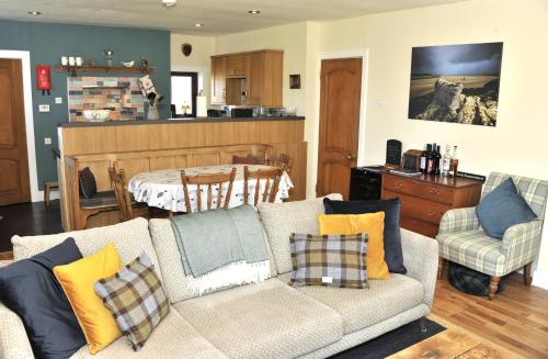 a living room with a couch and a kitchen at Taigh Tuaram in Carloway