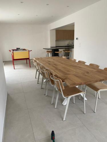 une grande table en bois et des chaises dans une pièce dans l'établissement Maison de vacances Wim & Chill, à Wimereux