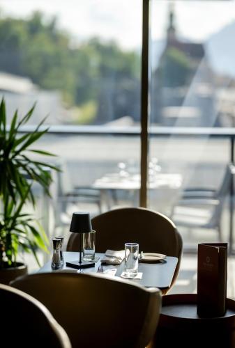 a table with two chairs and a table with a lamp at IMLAUER HOTEL PITTER Salzburg in Salzburg