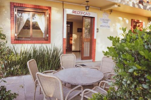 a table and chairs in front of a building at Pousada Drehmer Haus in Gramado