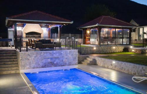 a swimming pool in front of a house with a gazebo at Villa Ivandvor in Sinj