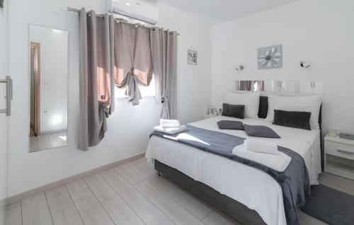 a white bedroom with a large bed and a mirror at Villa Ivandvor in Sinj