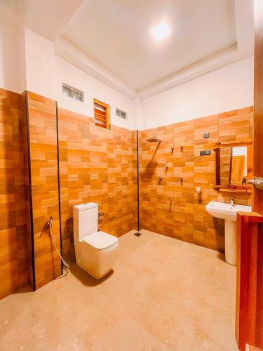 a bathroom with a toilet and a sink at Peak Bay Resort in Arugam Bay
