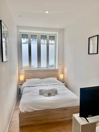 une chambre avec un lit, une fenêtre et une télévision dans l'établissement L'Alsacien - Villeurbanne - Métro A et B, à Villeurbanne