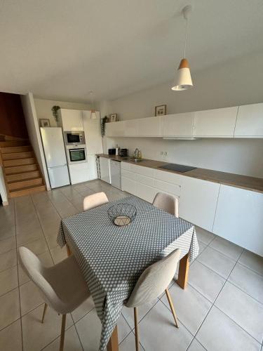 une cuisine et une salle à manger avec une table et des chaises dans l'établissement Maison le Gahignon 2, à Lanton