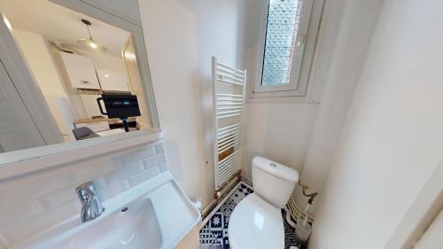 une salle de bain avec toilettes, lavabo et miroir dans l'établissement F3- Rue Amiral Courbet, au Havre