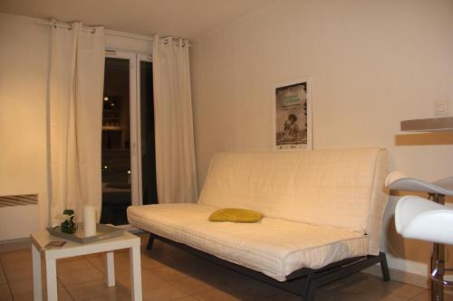 - un salon avec un canapé blanc et une fenêtre dans l'établissement Les Cyclades, à Arles