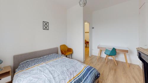 une chambre avec un lit, un bureau et des chaises dans l'établissement F3- Rue Amiral Courbet, au Havre