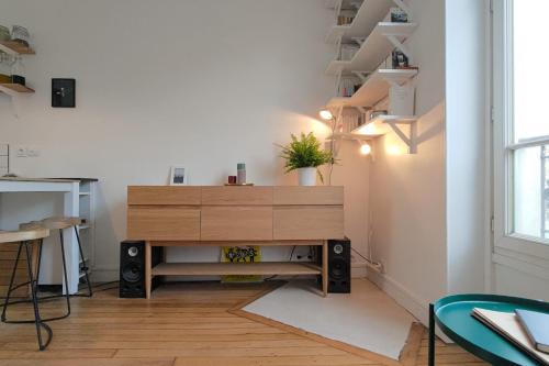 un salon avec une commode en bois et des escaliers dans l'établissement Cosy apartment in the 11th arrondissement, à Paris