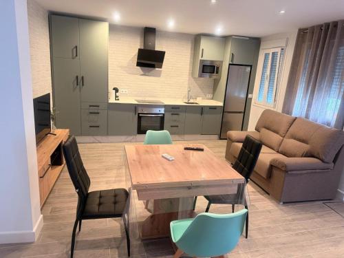 eine Küche und ein Wohnzimmer mit einem Holztisch und Stühlen in der Unterkunft 4vitas home in Bollullos de la Mitación