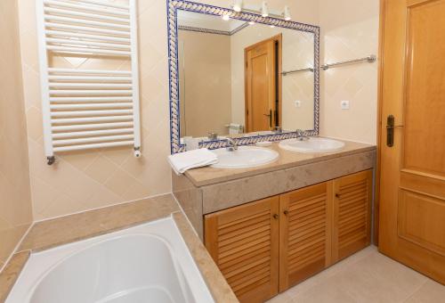 a bathroom with two sinks and a large mirror at T2 espaçoso Praia Del Rey, Óbidos piscina comum, Caravelas in Casal da Lagoa Seca