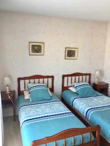 deux lits côte à côte dans une pièce dans l'établissement Les préludes vue Bassin, à Arcachon