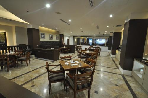 a restaurant with wooden tables and chairs in a room at Dreamtel Jakarta in Jakarta