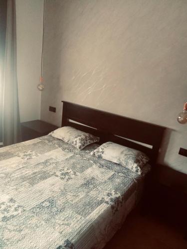 a bedroom with a bed with a wooden headboard at Alcudia Smir Complex in Fnidek