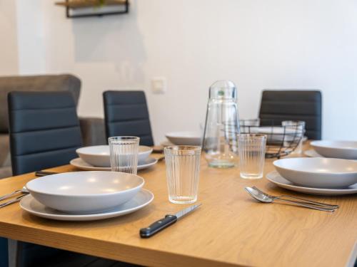 a wooden table with plates and bowls and glasses at el apartamento de la playa in Santander